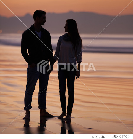 Couple, holding hands on beach and sunset, nature and travel with bonding for love and commitment outdoor. People with support, trust and loyalty with adventure together for honeymoon or anniversary 139883700