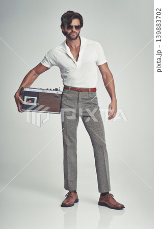 Men, fashion and confident with radio on retro in studio, grey background and smart clothes with elegant style. Trends, vintage and fashionable with old school in Italian look and classic outfit. Men, fashion and confident with radio on retro in studio, grey background and smart clothes with elegant style. Trends, vintage and fashionable with old school in Italian look and classic outfit. 139883702