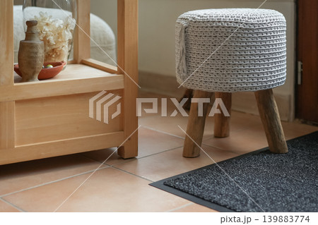 Cozy knitted stool near wooden shelf warm home interior decor Cozy knitted stool near wooden shelf warm home interior decor 139883774