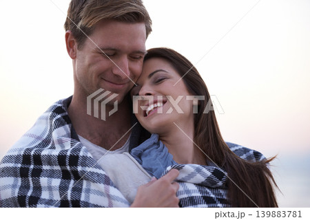 Couple, love and happy embrace at sunset with blanket together on holiday in Florida. Travel, vacation and man hug woman outdoor on date in summer with care, support and kindness in marriage 139883781