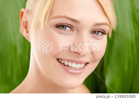 Leaf background, natural beauty and woman for skincare, organic cosmetics with nature and glow in studio. Green, vegan treatment for skin and dermatology with smile for sustainability in portrait Leaf background, natural beauty and woman for skincare, organic cosmetics with nature and glow in studio. Green, vegan treatment for skin and dermatology with smile for sustainability in portrait 139883880