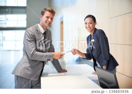 Receptionist, businessman and hotel for customer support, hospitality and check in for travel with brochure. Corporate people, smile and paper at table for service, promotion or help at front desk 139883936