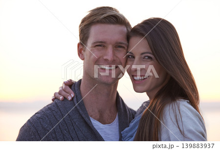 Love, hug and portrait of couple at ocean at sunset for tropical holiday adventure, relax and bonding together. Evening, happy man and woman on romantic date with beach, sky and embrace on vacation. 139883937