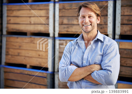Happy, portrait and mature man by wooden crates for delivery, shipping or exporting business. Industry, storage and professional male person crossed arms by pallets at outdoor distribution warehouse. 139883991
