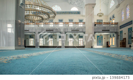 The interior view highlights the transition from the main prayer hall to the side aisles. Decorative arches frame the area, enhancing the space's cultural features. The interior view highlights the transition from the main prayer hall to the side aisles. Decorative arches frame the area, enhancing the space's cultural features. 139884173