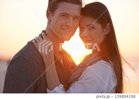 Couple hug, portrait on beach and sunset, nature and travel with bonding for love and commitment outdoor. People with support, trust and loyalty with adventure together for honeymoon or anniversary Couple hug, portrait on beach and sunset, nature and travel with bonding for love and commitment outdoor. People with support, trust and loyalty with adventure together for honeymoon or anniversary 139884198