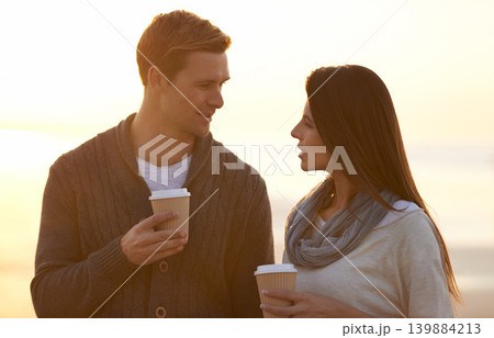 Couple, coffee and sunset at beach on vacation, walking and conversation in summer by ocean. Man, woman and drink with tea cup with smile, bonding and happy for memory on holiday by sea in Australia Couple, coffee and sunset at beach on vacation, walking and conversation in summer by ocean. Man, woman and drink with tea cup with smile, bonding and happy for memory on holiday by sea in Australia 139884213
