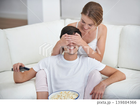 Couple, popcorn and covered eyes with sofa, surprise and remote for playful movie date. People, living room and film for relaxation, smile and bonding on couch with love and wow at home with break Couple, popcorn and covered eyes with sofa, surprise and remote for playful movie date. People, living room and film for relaxation, smile and bonding on couch with love and wow at home with break 139884366