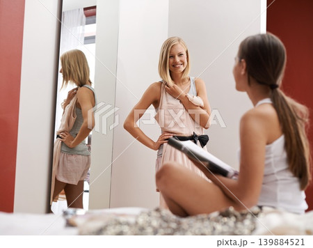 Friends, choice and clothes in bedroom for fashion, bonding and fun with magazine inspiration. Gen z women, female people and decision with smile, dress and mirror to get ready at home in Australia Friends, choice and clothes in bedroom for fashion, bonding and fun with magazine inspiration. Gen z women, female people and decision with smile, dress and mirror to get ready at home in Australia 139884521