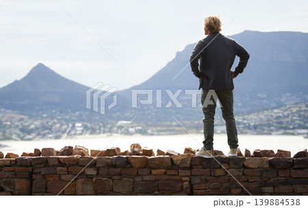 Man, watching mountains and thinking of adventure ideas and inspiration in Cape Town, South Africa. Male person and natural scenery for contemplating, planning and explore on wall with mock up Man, watching mountains and thinking of adventure ideas and inspiration in Cape Town, South Africa. Male person and natural scenery for contemplating, planning and explore on wall with mock up 139884538