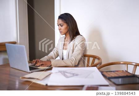 Black woman, desk and typing on laptop for small business, work from home and thinking of idea to design. African female owner, technology and research for architecture, career and entrepreneur 139884543