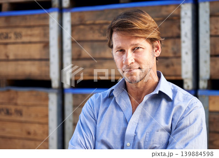 Smile, portrait and mature man by wooden crates for delivery, shipping or exporting business. Industry, storage and professional male person standing by pallets at outdoor distribution warehouse. 139884598