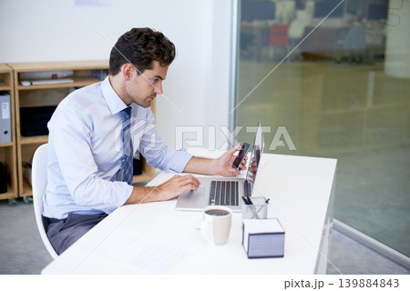 Research, office and businessman with phone, laptop and coffee at startup with technology. Browse, online and business analyst at desk with computer, smartphone and internet connection for networking 139884843
