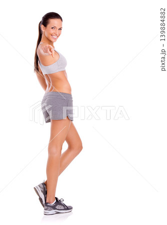 Studio, model and pointing in portrait for exercise promotion and training announcement or news of gym discount. Woman, happy face and aerobics offer for choice and workout plan by white background 139884882