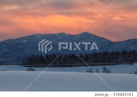 夕焼けの美しい雲とグラデーション空に映える冬の雪山と広大な雪原 夕焼けの美しい雲とグラデーション空に映える冬の雪山と広大な雪原 139885501