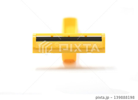 A Close Up Shot of a Yellow Plastic Disposable Razor Showing Sharp Twin Blades Isolated on a Soft Clean White Background with Copy Space A Close Up Shot of a Yellow Plastic Disposable Razor Showing Sharp Twin Blades Isolated on a Soft Clean White Background with Copy Space 139888198