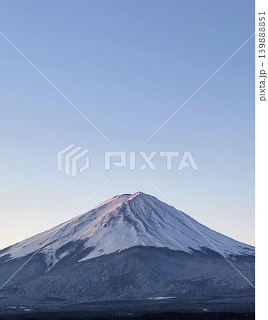 冬ばれの朝の白から青に変化する大空の下で霊峰富士が裾広がりに安定して構える純白の冬富士 139888851