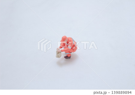 Miniature sanitation worker crouching collecting waste Miniature sanitation worker crouching collecting waste 139889894
