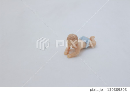 Baby crawling miniature figure isolated on white 139889898