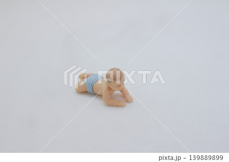 Baby crawling miniature figure isolated on white 139889899