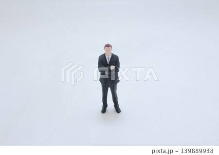 Miniature businessman standing with arms crossed confidently Miniature businessman standing with arms crossed confidently 139889938