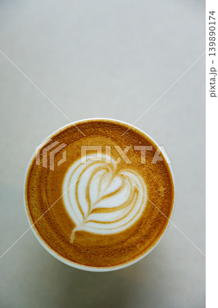 Cup of hot milk latte coffee with heart shape latte art on table. Cup of hot milk latte coffee with heart shape latte art on table. 139890174