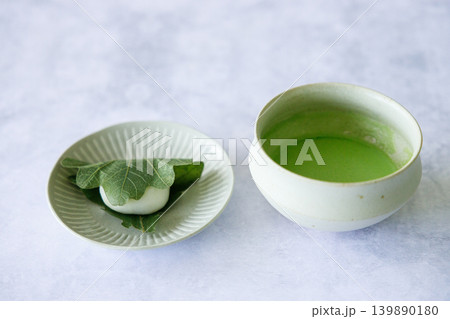 Kashiwa mochi and Cup of fresh matcha tea. Japanese sweet from mochi or rice cake and sweet red bean paste filling surrounded with Kashiwa or Oak leaf . 139890180