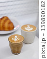 Cup of hot milk piccolo latte coffee and hot cappucino with croissant on white table. 139890182