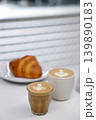 Cup of hot milk piccolo latte coffee and hot cappucino with croissant on white table. 139890183