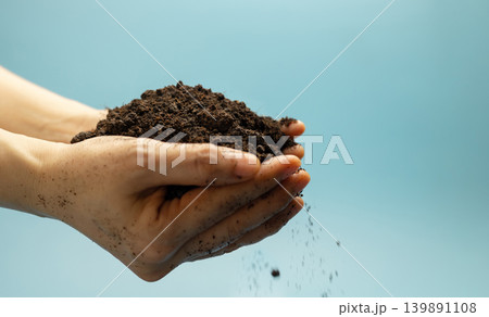 Hands holding fertile soil against blue sky,Agriculture, environmental sustainability Hands holding fertile soil against blue sky,Agriculture, environmental sustainability 139891108