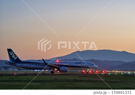 夕暮れの仙台空港　タキシング中の飛行機と蔵王連峰　宮城県名取市 139891331