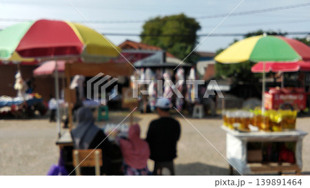 A blurry view of a traditional market with colorful umbrellas. 139891464
