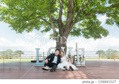 LOVEのオブジェの前でウェディングフォトを撮る新郎新婦 LOVEのオブジェの前でウェディングフォトを撮る新郎新婦 139891527