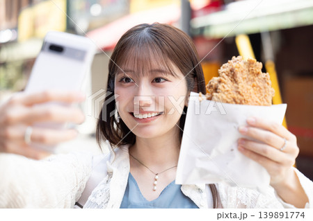 横浜中華街で食べ歩きを楽しむ女性 139891774