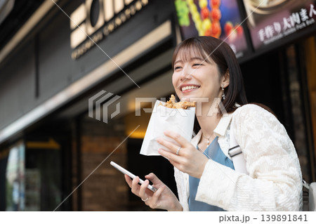 横浜中華街で食べ歩きを楽しむ女性 横浜中華街で食べ歩きを楽しむ女性 139891841