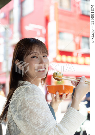 横浜中華街で食べ歩きを楽しむ女性 139891874