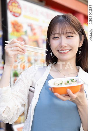 横浜中華街で食べ歩きを楽しむ女性 横浜中華街で食べ歩きを楽しむ女性 139891887
