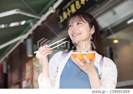 横浜中華街で食べ歩きを楽しむ女性 横浜中華街で食べ歩きを楽しむ女性 139891889