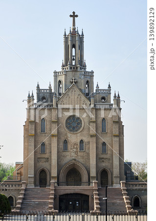 Roman Catholic church of the Sacred Heart of Jesus in Tashkent. Gothic style architecture with stone facade and steeple tower. Religious building landmark in Uzbekistan. Heritage site. Roman Catholic church of the Sacred Heart of Jesus in Tashkent. Gothic style architecture with stone facade and steeple tower. Religious building landmark in Uzbekistan. Heritage site. 139892129