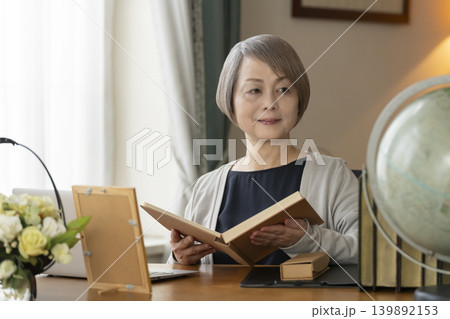 自宅の書斎でリモートワークをするシニア女性 139892153