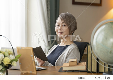 自宅の書斎でリモートワークをするシニア女性 139892156