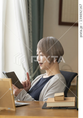 自宅の書斎でリモートワークをするシニア女性 自宅の書斎でリモートワークをするシニア女性 139892167
