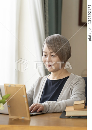 自宅の書斎でリモートワークをするシニア女性 139892171