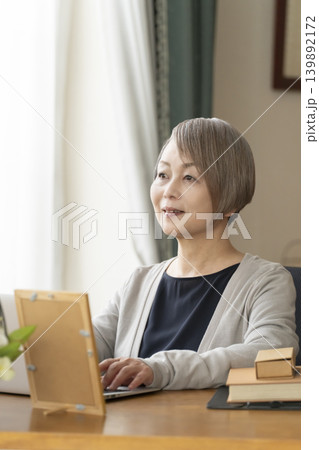自宅の書斎でリモートワークをするシニア女性 139892172