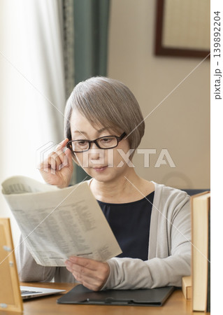 自宅の書斎でリモートワークをするシニア女性 自宅の書斎でリモートワークをするシニア女性 139892204