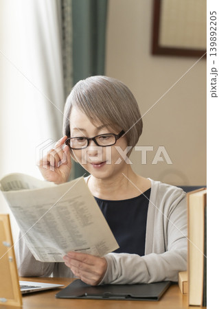 自宅の書斎でリモートワークをするシニア女性 自宅の書斎でリモートワークをするシニア女性 139892205