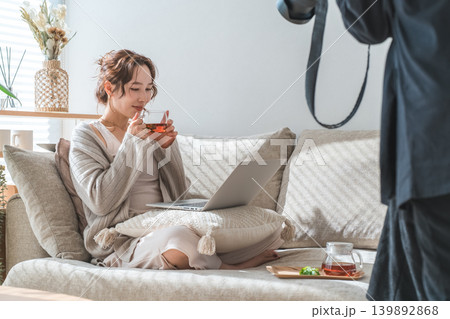 ソファーに座り紅茶を飲みながらパソコンを見る女性の撮影風景 ソファーに座り紅茶を飲みながらパソコンを見る女性の撮影風景 139892868