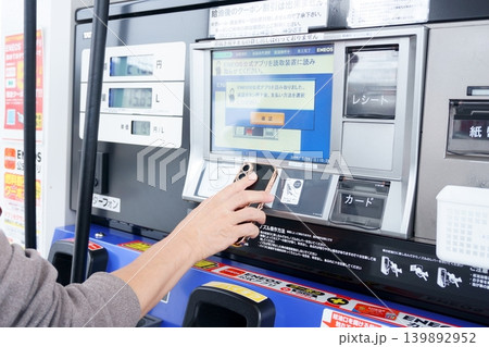 ガソリンスタンドの給油機を操作する男性の手元 139892952