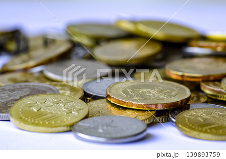 Closeup view of mixed coins scattered and stacked together on a reflective surface, emphasizing financial savings and currency. Closeup view of mixed coins scattered and stacked together on a reflective surface, emphasizing financial savings and currency. 139893759