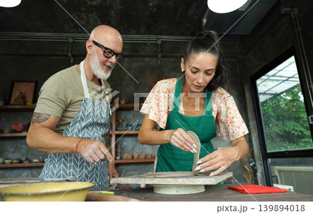 A happy couple makes ceramic plates in a workshop 139894018